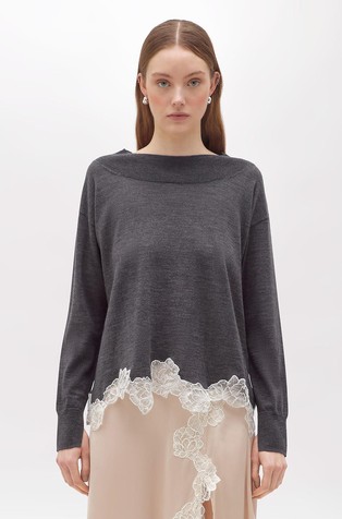 Pleten vuneni pulover s cvjetnom aplikacijom